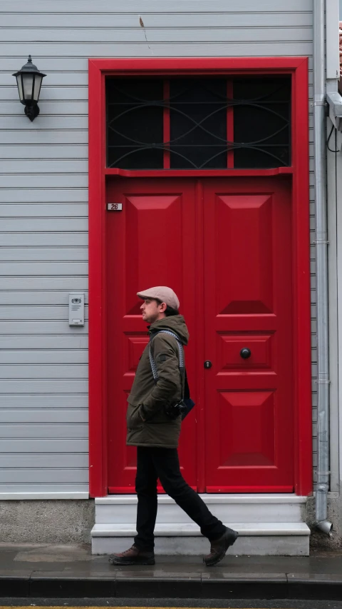 a person walks by a large red door