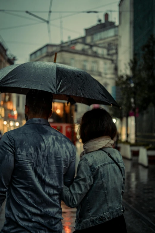 couple under umbrella in the rain walking down the street