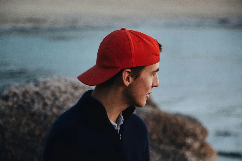 a man with a red hat stares into the distance