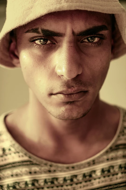 a young man wearing a beige hat