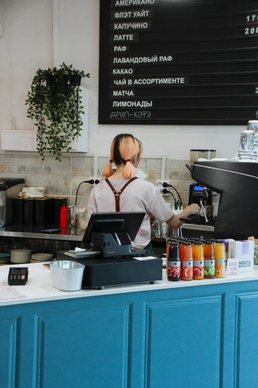 a woman behind a counter with many items on it