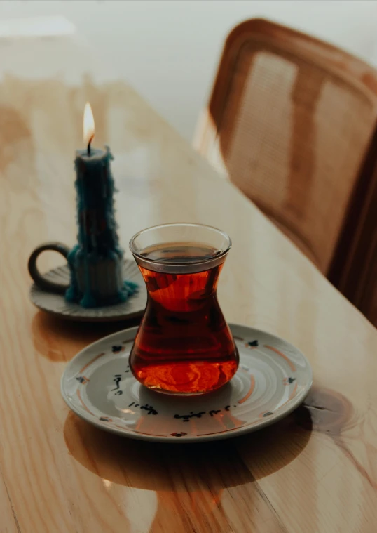 a glass teapot and plate on a wooden table