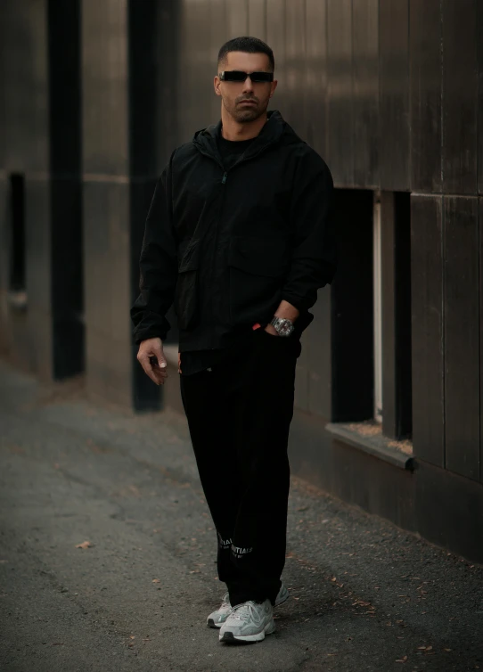 a man with sunglasses on walking down a sidewalk