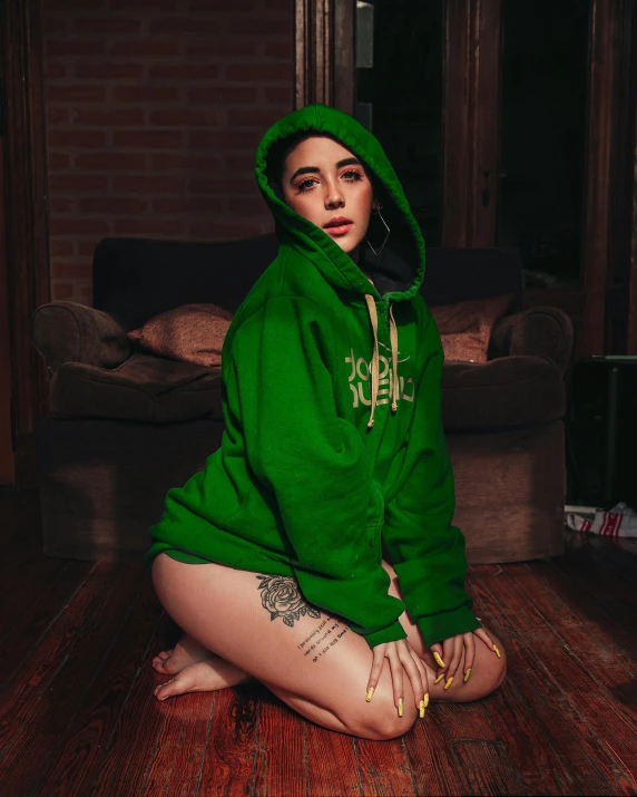 a person that is sitting on the floor wearing a hoodie