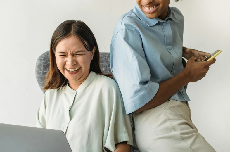 a woman on a laptop computer, and an older woman smiling with a hand held cigarette