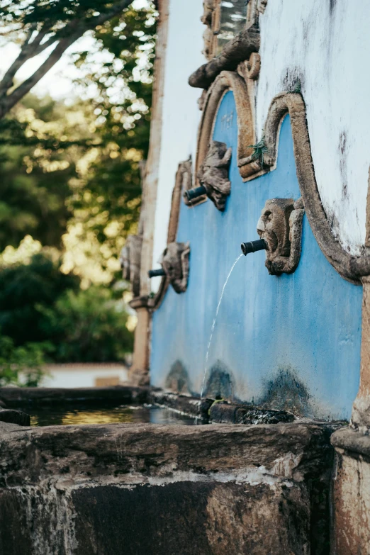 a water fountain with many animal heads on it