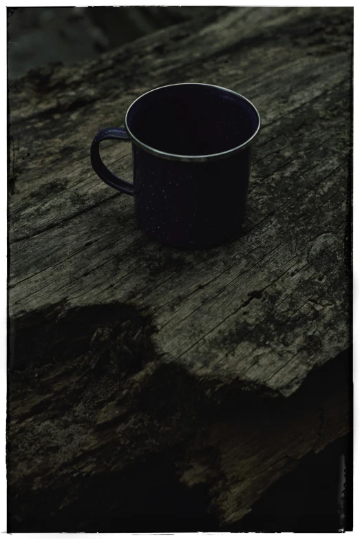 a black cup is placed on the wooden table