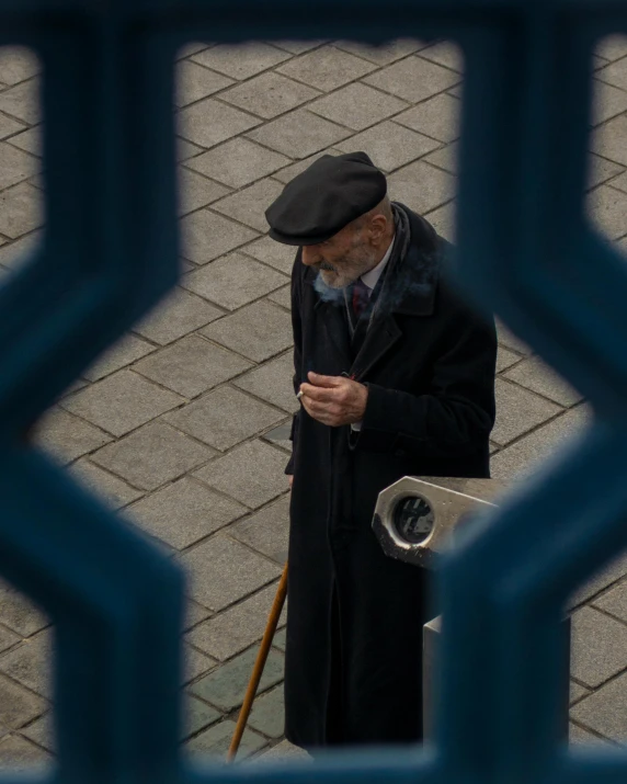 man standing on the sidewalk holding an umbrella