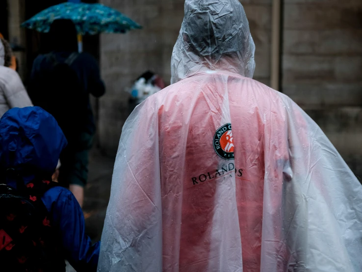 there is a woman wearing a raincoat and a little girl walking