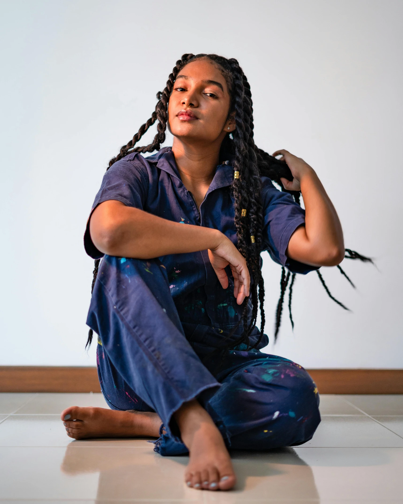 a young woman sits with her hand on her shoulder