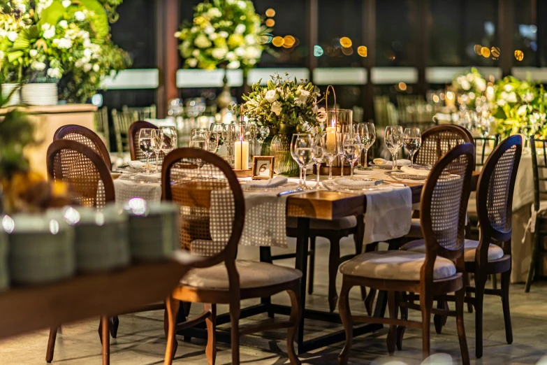 an outdoor dining room has a long table with many chairs and place settings