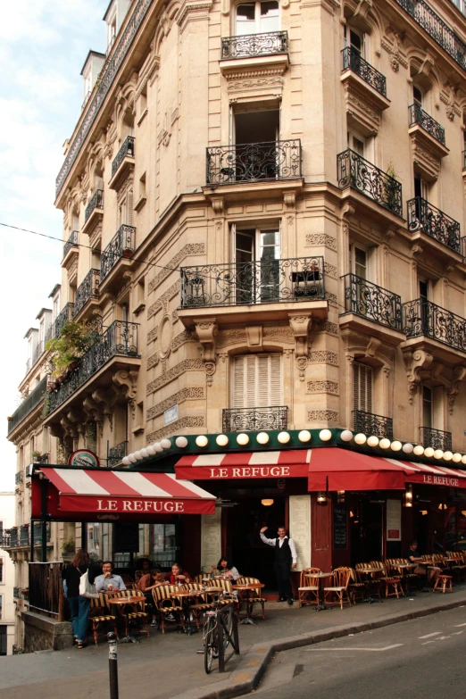 people dining outside at tables on a street corner