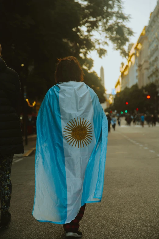 a person walks with a blue cover over their shoulders