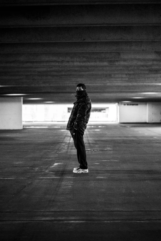 the man in black jacket rides on skateboard in the dark