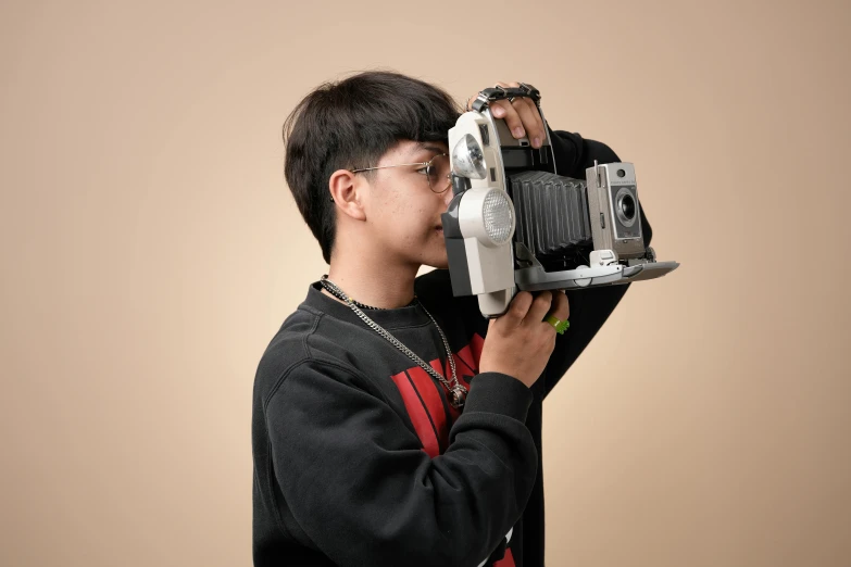 a boy holding up a video camera to his face