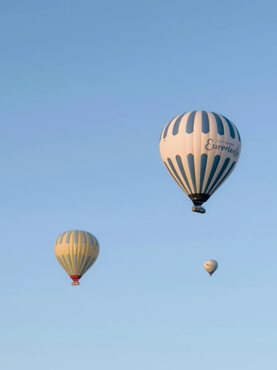 a couple of  air balloons flying over a hill