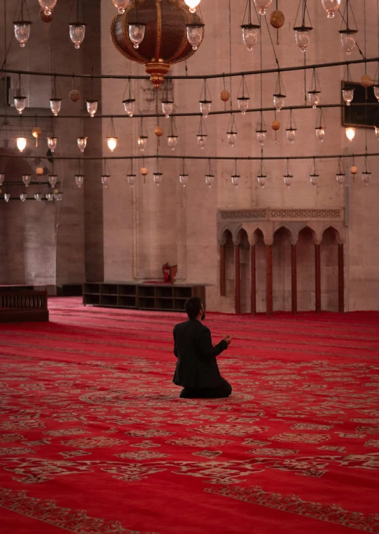 a person kneeling down and praying in an empty room