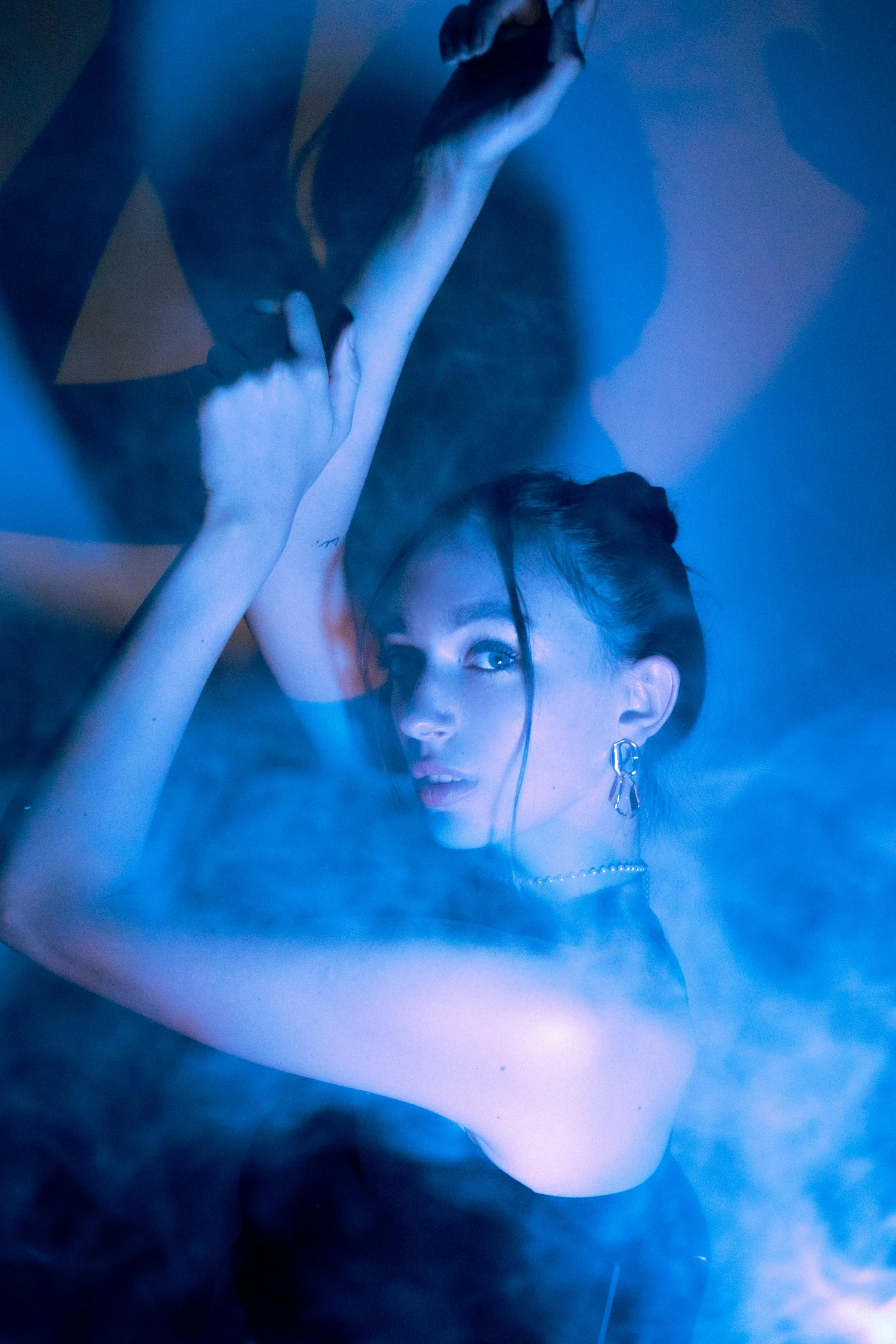 a woman holding a knife with a liquid in the background