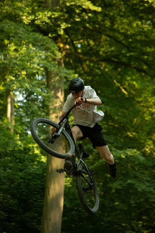 a boy on his bike is trying to do a trick in the air