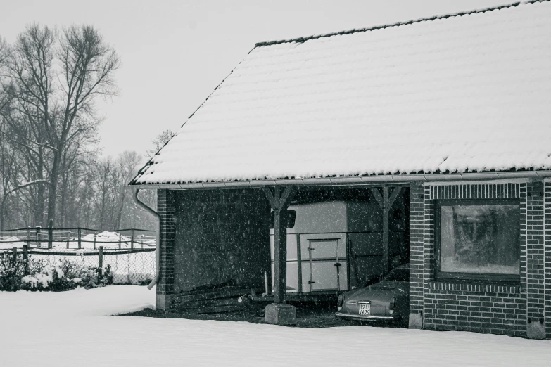 a black and white image of the outside of a house in the snow