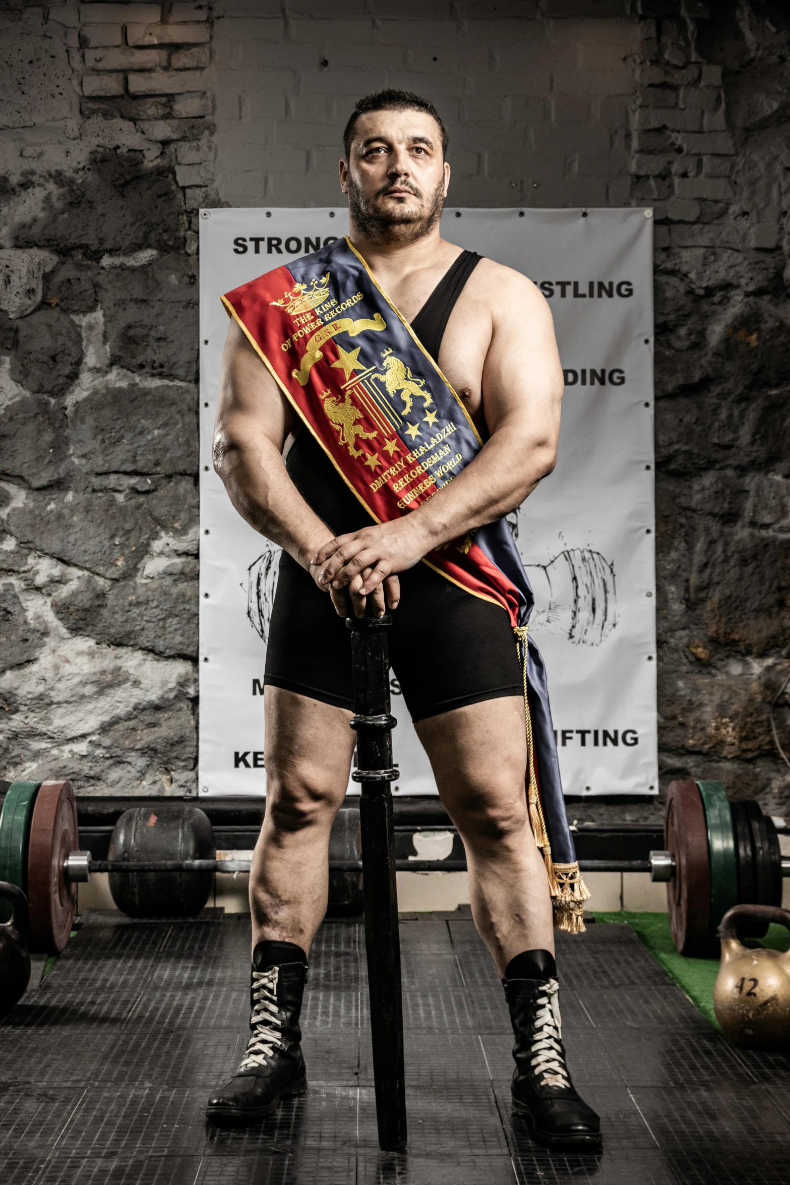 a man is posing for a po holding a barbell