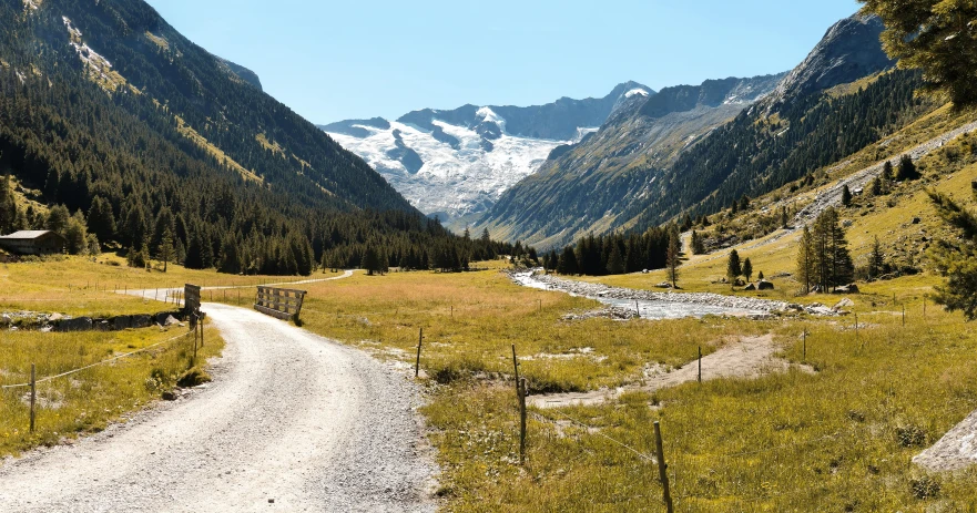 a long dirt path splits in two different directions with mountains on the far side