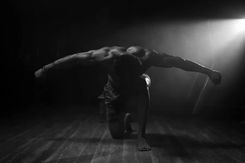 a man performs a handstand on a wooden floor