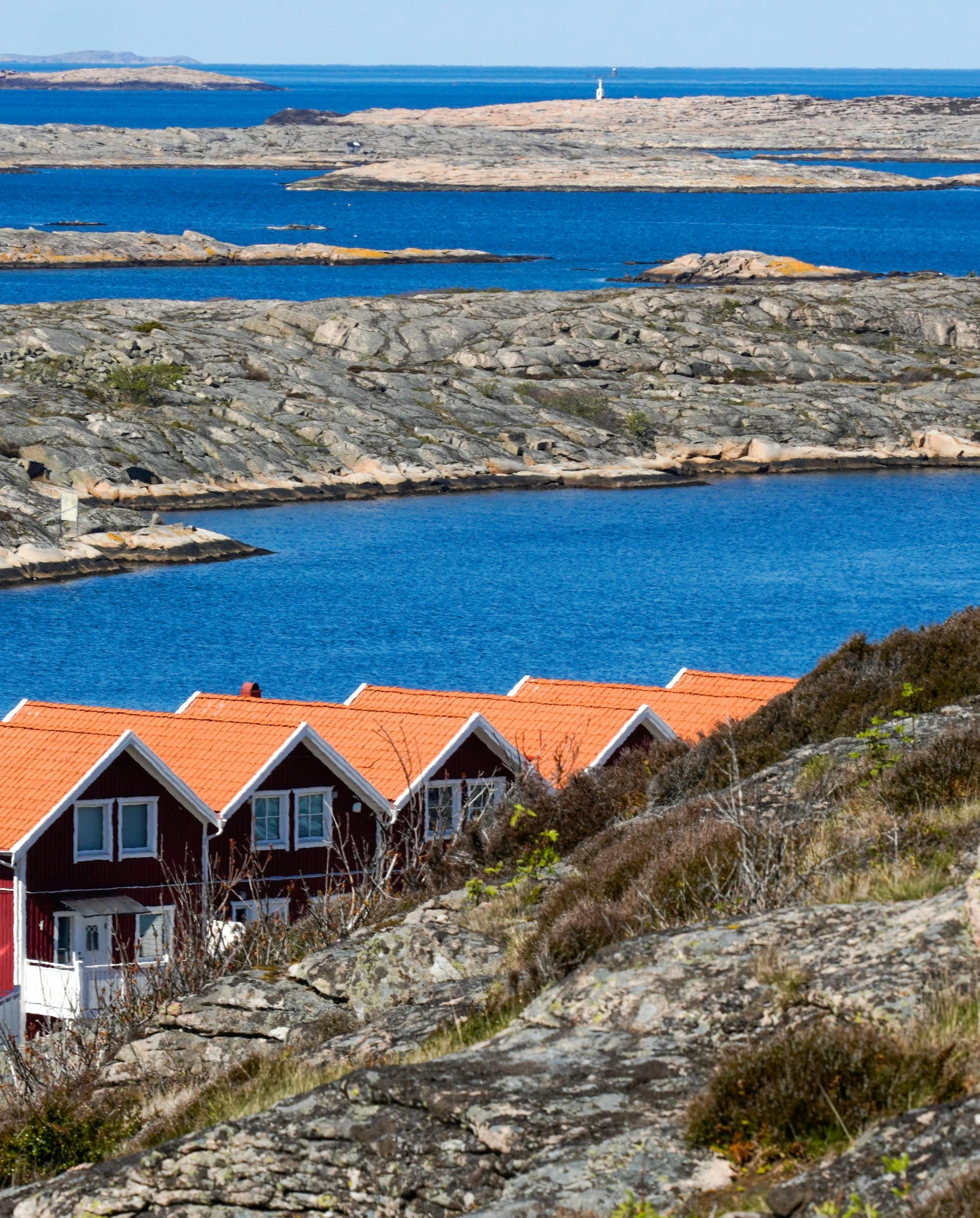 houses on the rocky hillside next to a lake