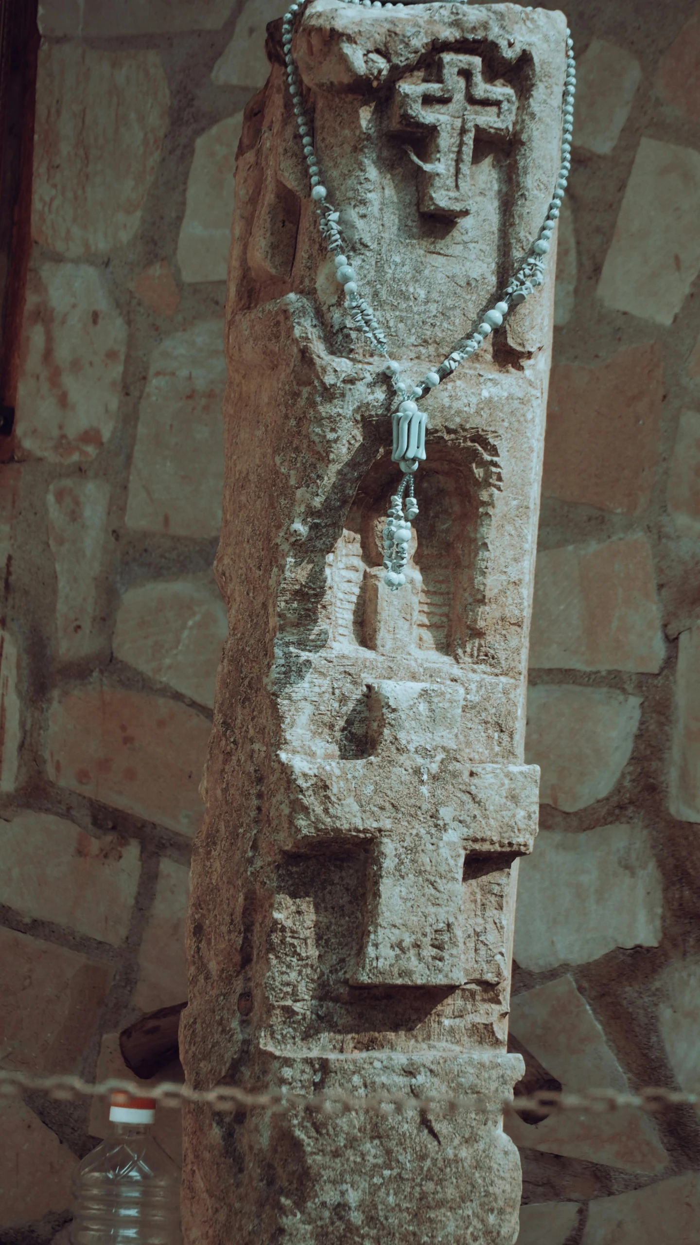 the statue is adorned with a large silver rosary