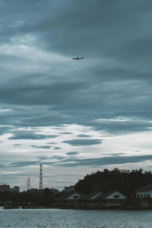 a body of water with several buildings around it and an airplane flying over it