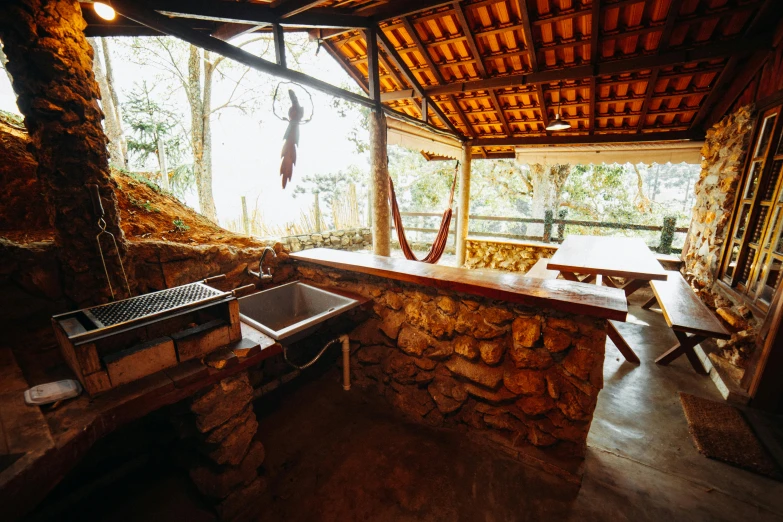 a bar inside an outdoor room with two sinks