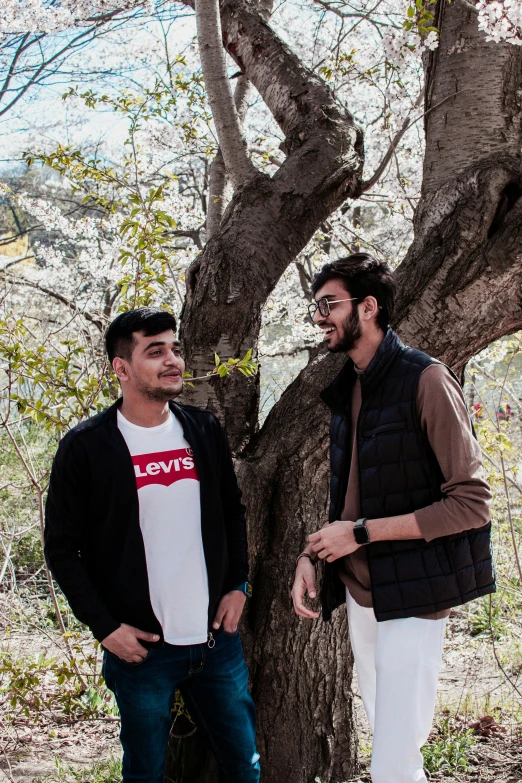 two men standing in front of a tree