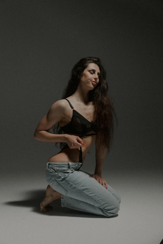 woman sitting on floor wearing  top, jeans and heels