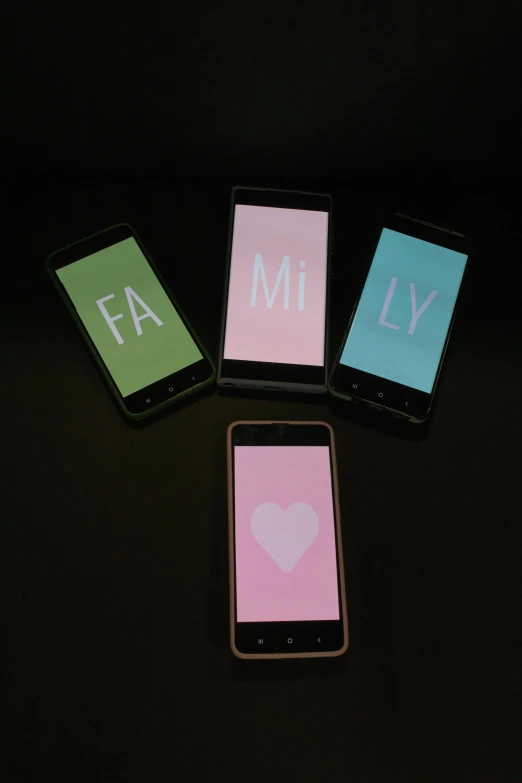 four pink, teal and white cards and an iphone on a black background