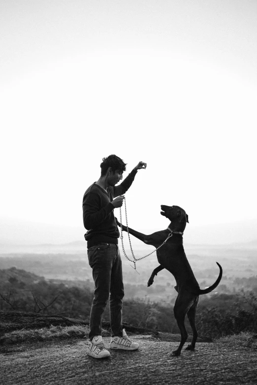 black and white pograph of a man holding a dog