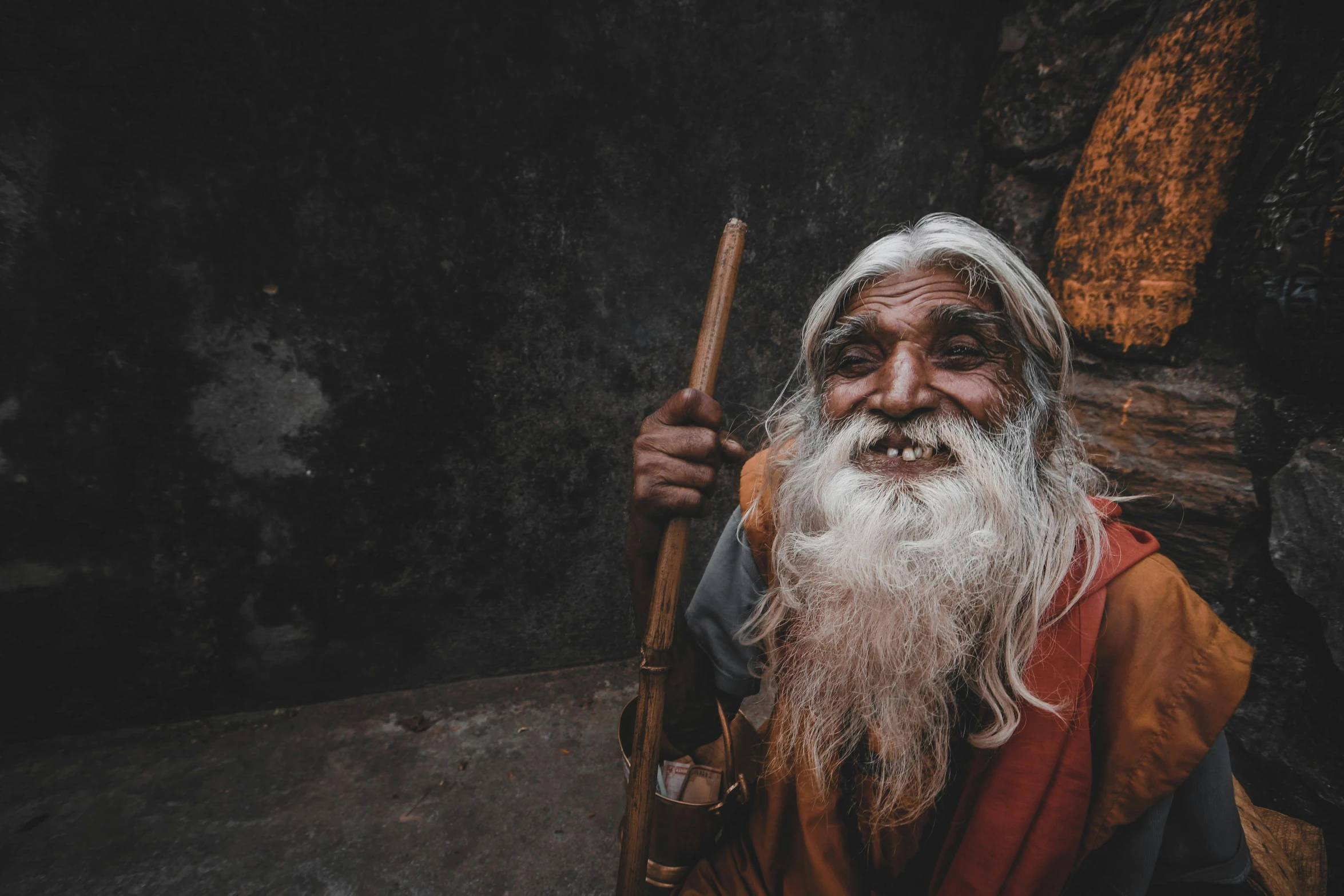 an elderly man wearing a long white beard and holding a stick