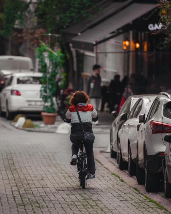 woman rides bicycle down a brick city street