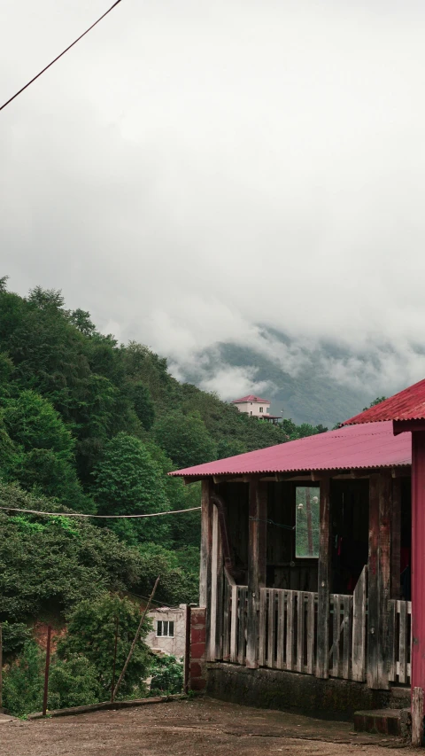 a pink house near the mountains during cloudy weather