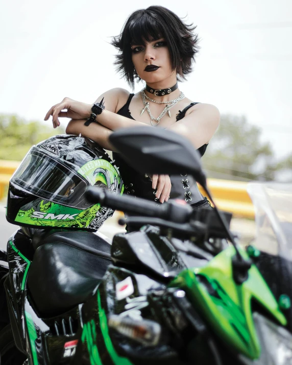 a woman with short hair posing with her motorcycle