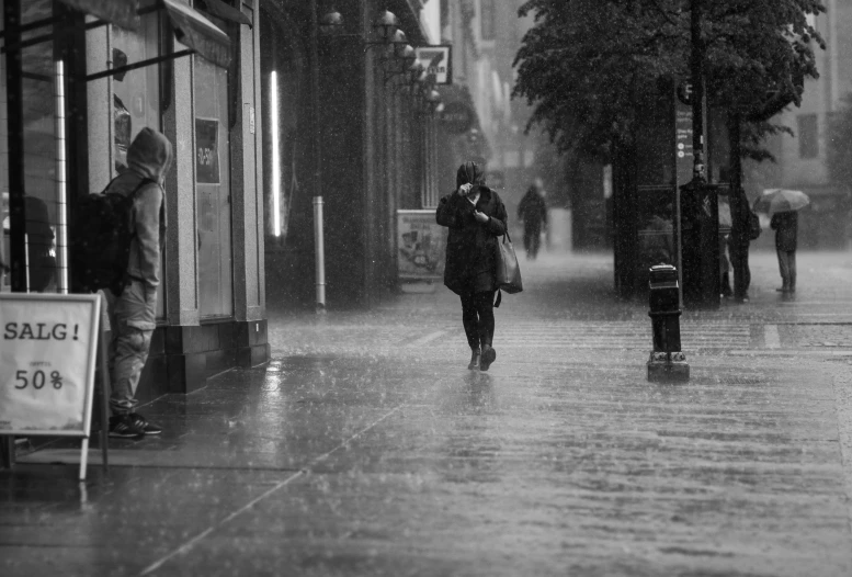 people walking down a street in the rain