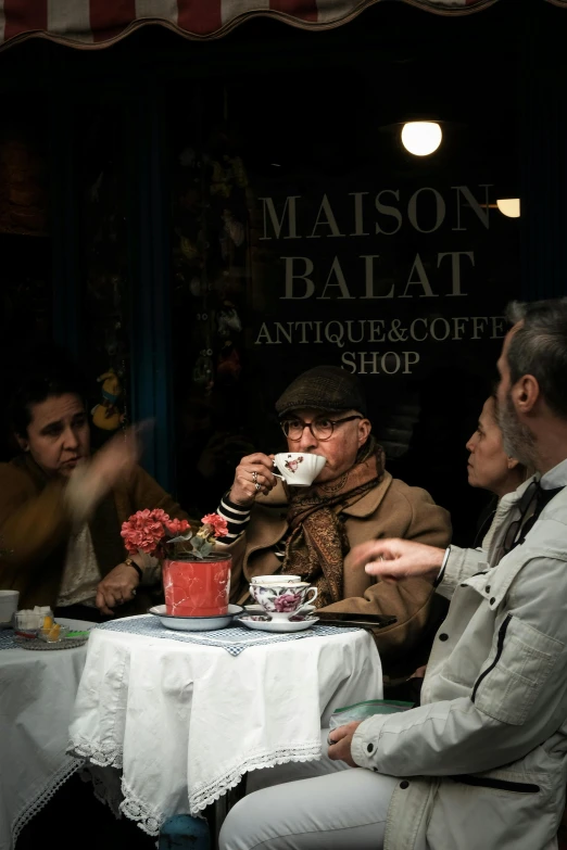 a group of people sitting at a table having coffee