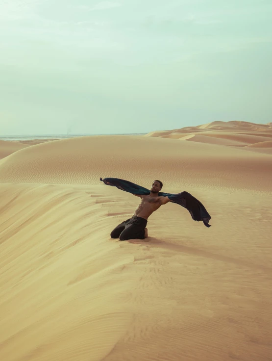 a man with an outstretched body in the sand