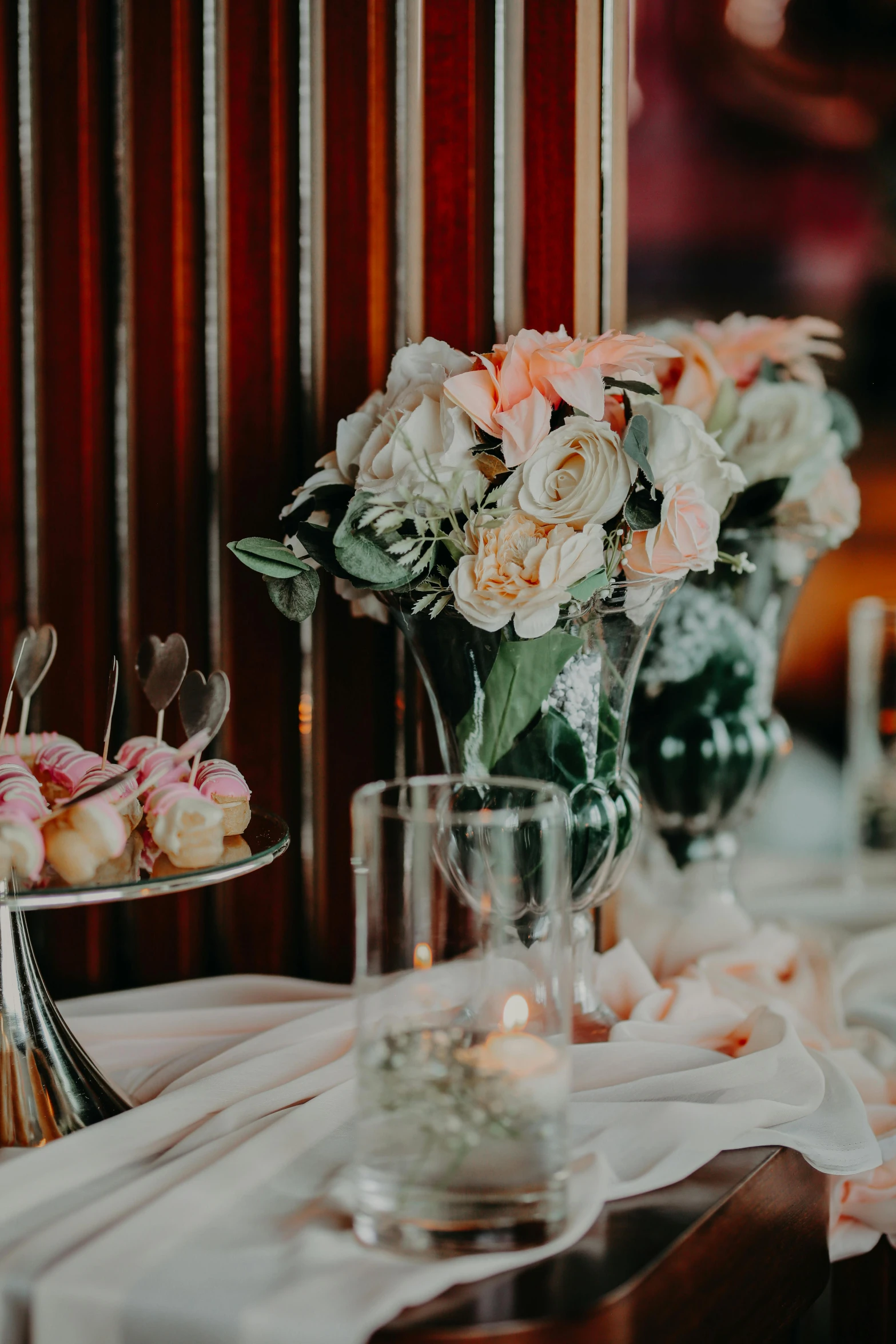 cupcakes on plates next to flowers in vases