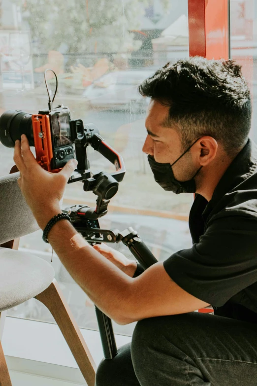 a man on a tripod is making adjustments to the camera