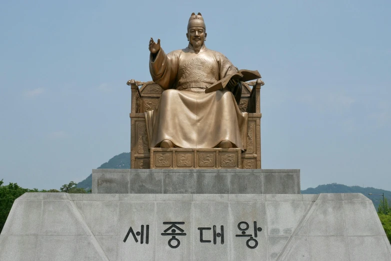 a large bronze statue of buddha sitting on a chair