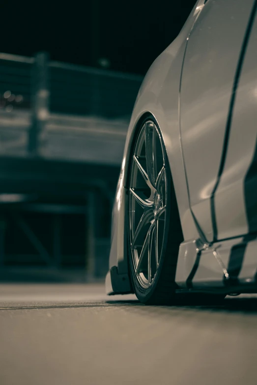 the wheels of a silver sports car parked on the street