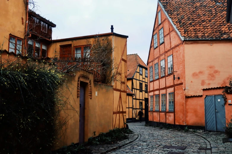 a cobble stone street with red brick buildings