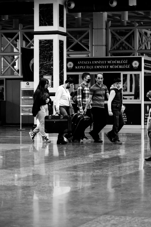 many people in a station waiting for their baggage