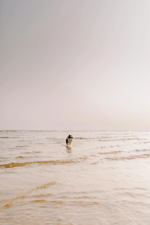 a person walking in the ocean and holding onto soing