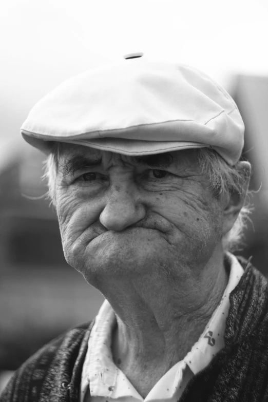 an older man wearing a hat and looking angry